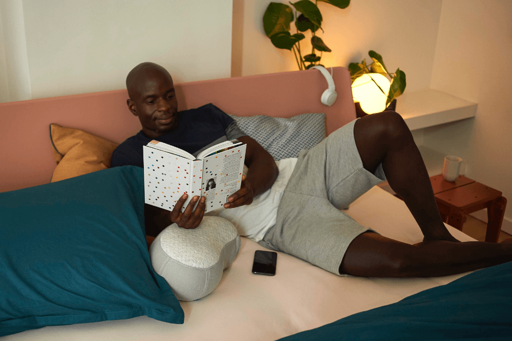 man reading a book in bed