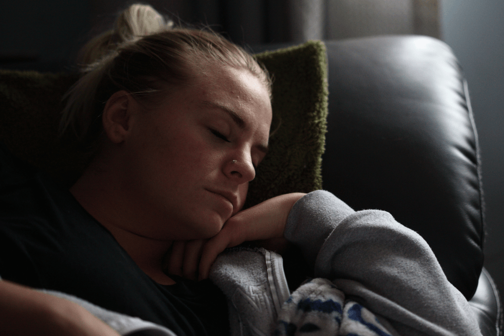 woman sleeping in black couch